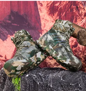 Close-up of tactical camo boots on rock featuring reinforced soles and metal lace buckles