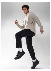 Dynamic full shot of men's black chunky sneakers with casual light beige sweatshirt set