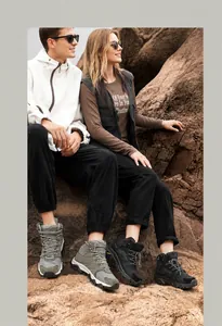 Detail of breathable hiking boots showing traction sole and mesh upper on rocky terrain