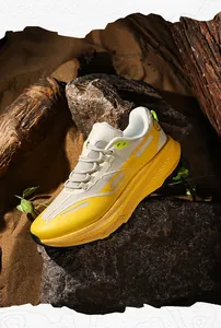 Detailed view of yellow and beige outdoor trail running shoes on a rocky desert landscape