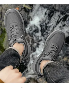 Nahaufnahme von Herren-Winterschuhen mit dickem Kunstfellfutter auf felsigem Bachhintergrund