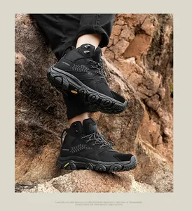 Detail of durable black outdoor hiking boot with rubber sole on rocky terrain