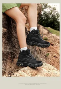 Close-up of durable black high-top hiking boots with rugged outsoles on rocky terrain
