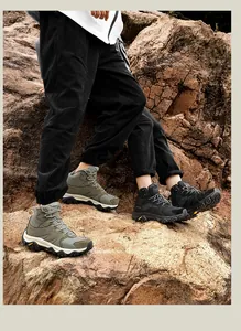 Close-up of mesh and leather hiking boots with outdoor grip soles on rocky terrain