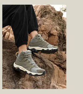 Detail of outdoor hiking boot with army green mesh and non-slip rubber outsole on rocks