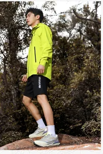 Detail of neon green windbreaker and black sports shorts for outdoor hiking and trail running