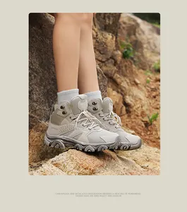 Outdoor hiking boots in khaki showing textured mesh and rugged anti-slip sole on rocks