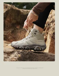 Detail of khakhi hiking boots with non-slip rubber soles and OUTDOOR logo on rocks