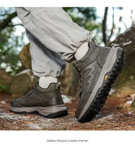 Detailed side view of men's winter hiking boots with anti-slip rubber soles in outdoor terrain
