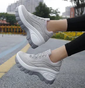 Dettaglio della tomaia in mesh grigio traspirante e suola spessa di scarpe da ginnastica