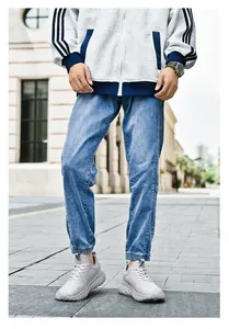 Detail view of light blue jogger jeans with elasticated cuffs and washed denim texture