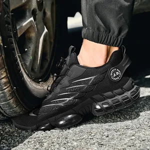 Chaussures de sécurité respirantes noires avec coussin d'air testées sous un pneu de voiture