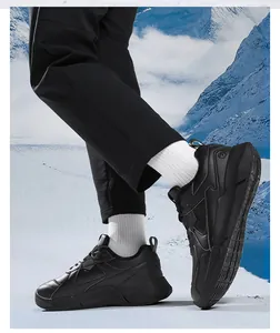 Detail eines schwarzen Outdoor-Sportschuhs mit dicker Sohle und rutschfestem Profil im Schnee