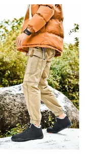 Detail of warm winter outdoor outfit featuring orange puffer jacket and fleece-lined shoes