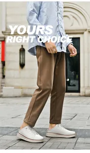 Close-up of stylish brown men's casual trousers paired with white leather mule sneakers