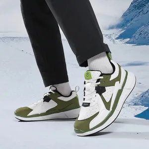 Sneaker casual da uomo classiche in bianco e verde oliva su sfondo di montagna innevata