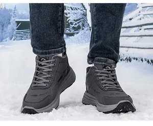 Detail of dark grey winter boots with thick warm plush lining on snow background