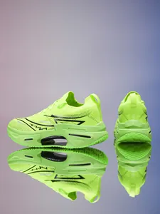 Detalle de zapatilla de running verde neón transpirable con suela hueca y reflejo de espejo
