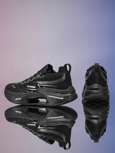 Detalle de zapatos de running negros transpirables con logo RETRO y suela gruesa