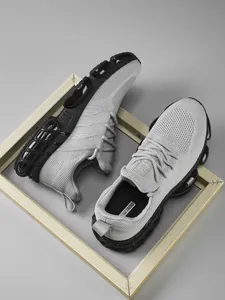 Detail showing breathable grey knit fabric and thick black cushioned air sole for sports shoes
