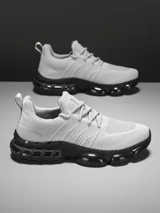 Close-up of men's gray knitted sneakers featuring futuristic black cushioned air bubble soles
