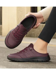 Detail of burgundy leather mule sneakers featuring textured upper and thick black sole