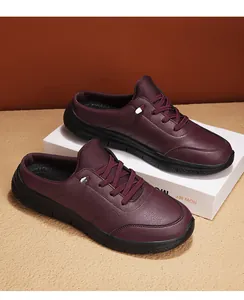 Detail view of burgundy faux leather mule sneakers with black non-slip rubber soles