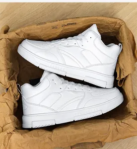 Vue de dessus de baskets blanches mi-hautes sur papier kraft et sol en bois
