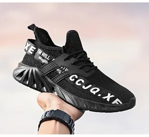 Detail van zwarte ademende mesh sneakers met witte letters en een dikke rubberen zool