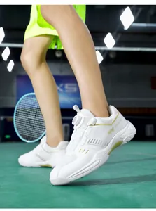 Detail of white indoor badminton shoes with gold accents and a rotary knob lacing system