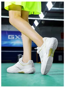 Detail of white indoor badminton shoe with non-slip sole and rotary buckle lacing system