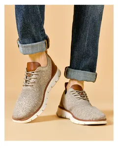 On-foot shot of men's khaki breathable knit sneakers with premium brown leather details