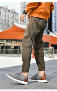 Close-up of gray knitted sneakers with brown leather details on an urban background