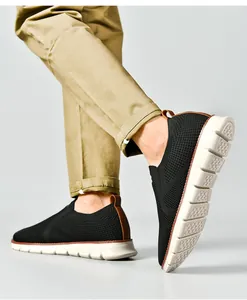 Détail de mocassins noirs respirants en tricot pour hommes avec semelles blanches flexibles