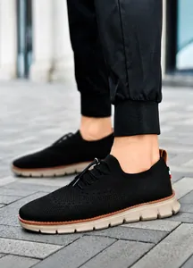 Dettaglio scarpa in maglia nera con mesh traspirante e cinturino tricolore