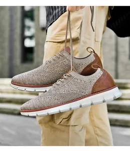 Detail of khaki flyknit men's sneaker featuring brown leather heel with brogue punching