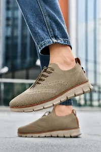 Dettaglio di scarpe da uomo in maglia traspirante kaki con fibbia elastica su strada