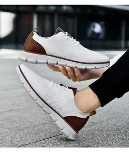 Detail view of white breathable mesh knit fabric with brown brogue leather stitching on the heel