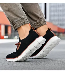 Close-up of black breathable mesh sneakers with brown leather accents and white rubber soles