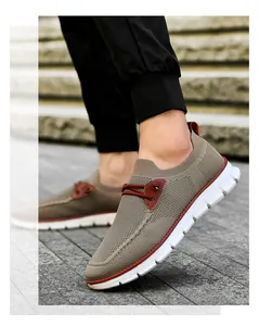 Detail of breathable khaki knit sneaker with leather accents on natural stone stairs