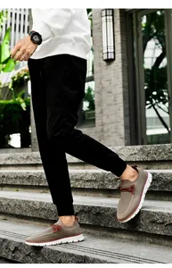 Outdoor shot of breathable brown knit slip-on sneakers with white anti-slip thick soles