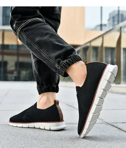 Gros plan de baskets en maille noire pour hommes avec languette de talon en cuir brun