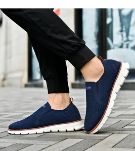 Détail de baskets en maille respirante bleu marine avec languette marron et semelle blanche