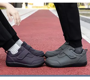 Dettaglio di scarpe da trekking con velcro su una pista da corsa rossa all'aperto