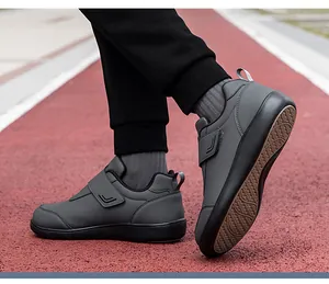 Dettaglio di scarpe da camminata grigie con chiusura a strappo su una pista da corsa