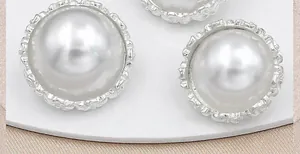 Detalle macro de botones de perlas redondas con bordes plateados tallados para chaquetas