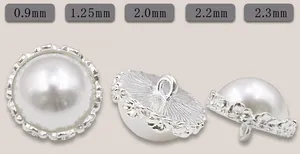 Vista detallada de botones de perlas vintage plateados con relieve floral y tallas