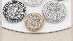 Vue macro de boutons en métal vintage ornés de strass brillants en trois coloris
