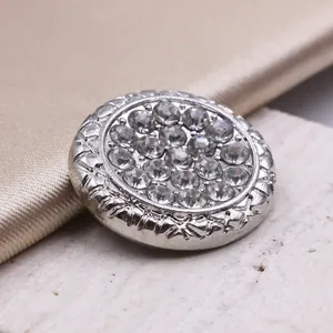 Bottone rotondo vintage in metallo argento con strass e texture su raso