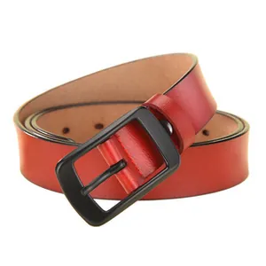 Detailed macro view of red leather belt with matte black buckle and clean stitch holes